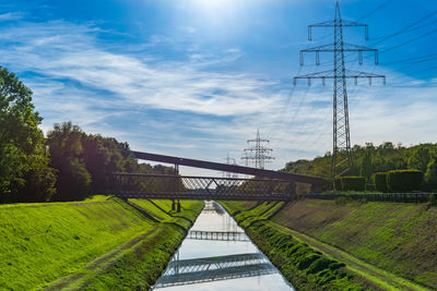 View of canal, high voltage posts and steel bridge over canal at nordsternpark in gelsenkirchen.