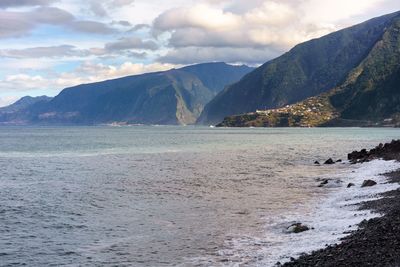 Scenic view of sea and mountains against sky