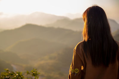 Rear view of woman looking at mountain range