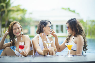 Young woman drinking water from while sitting outdoors