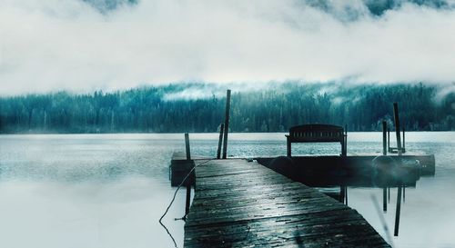 Pier over lake against sky during winter