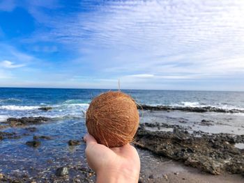 Person holding ice cream on beach