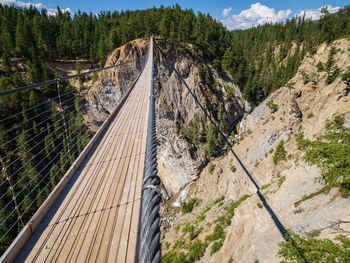 Wooden suspension bridge across steep canyon 