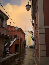 Narrow street amidst buildings in city against sky