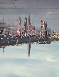 Reflection of electricity pylon in amusement park against sky