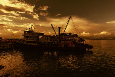 Sailboats sailing on sea against sky during sunset