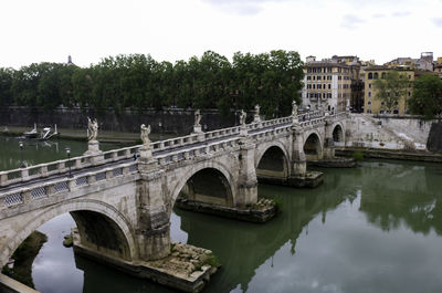 Arch bridge over river against sky