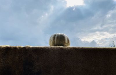 Low angle view of hay bales on land against sky