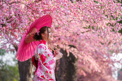 Woman standing on pink flowering plants