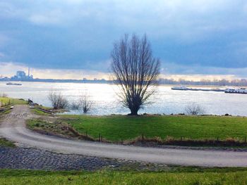 Scenic view of river against cloudy sky