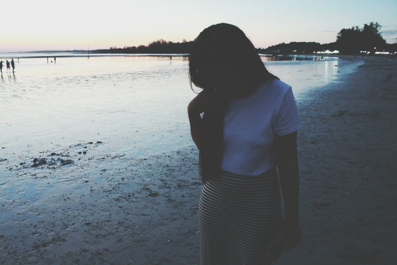 water, beach, lifestyles, sea, leisure activity, standing, shore, rear view, sunset, casual clothing, three quarter length, tranquility, full length, sky, nature, tranquil scene, person, beauty in nature