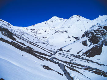 Scenic view of snowcapped mountains against clear blue sky