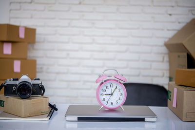 Close-up of clock on table against wall