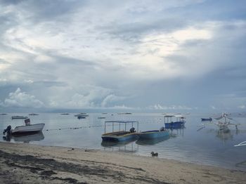 Boats moored on beach against sky