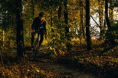 Man standing by trees in forest