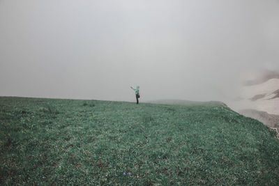 Side view of person standing on field during foggy weather