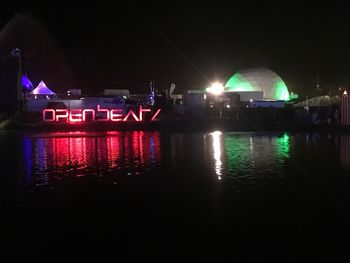 Illuminated bridge over river at night