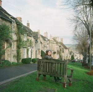 Man in park by buildings against sky