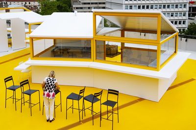 Rear view of woman standing against yellow building