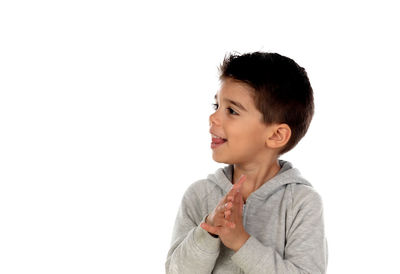 Cute boy looking away against white background