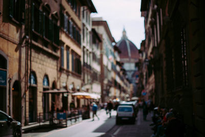People on street amidst buildings in city