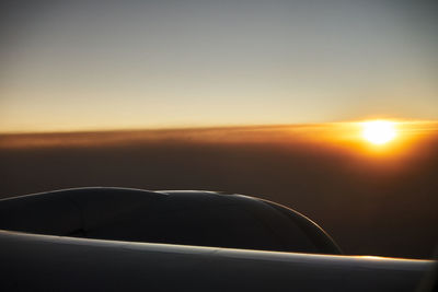 Close-up of airplane against sky during sunset