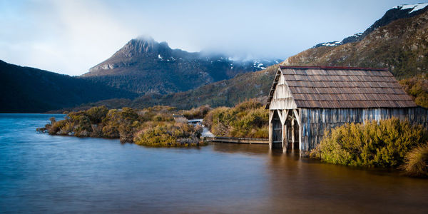 Scenic view of lake by buildings against sky