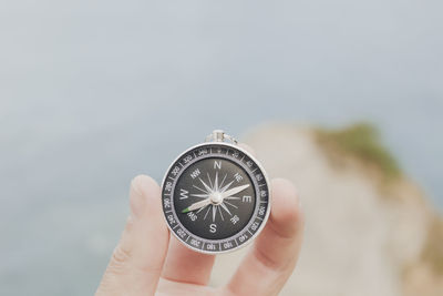 Cropped hand holding navigational compass