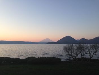 Scenic view of lake against clear sky during sunset