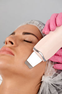 Close-up of young woman holding thermometer