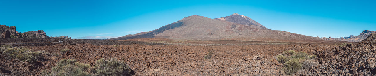 Scenic view of rocky mountains against clear blue sky