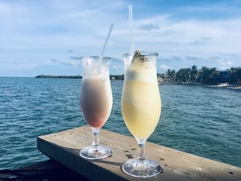Close-up of wine glass on table against sea