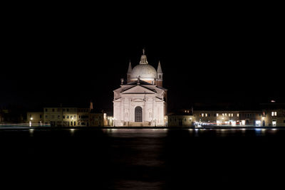 Illuminated building against sky at night