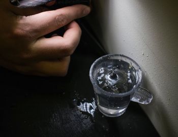 Close-up of hand by water glass