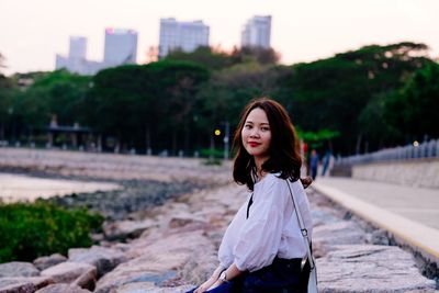 Portrait of woman sitting on rock