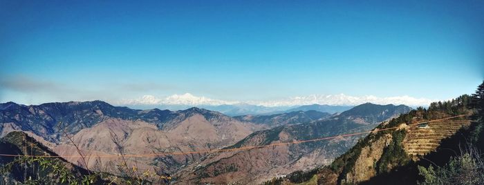 Panoramic view of mountains against blue sky