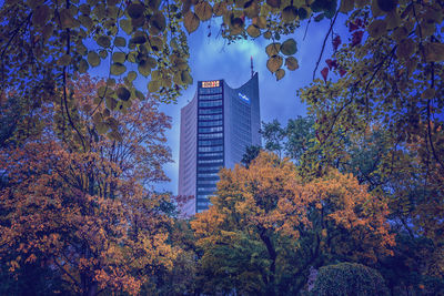 Low angle view of trees and buildings against sky