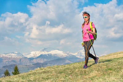 Woman standing on mountain against sky