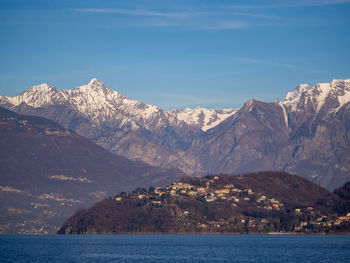 Scenic view of snowcapped mountains by sea against sky