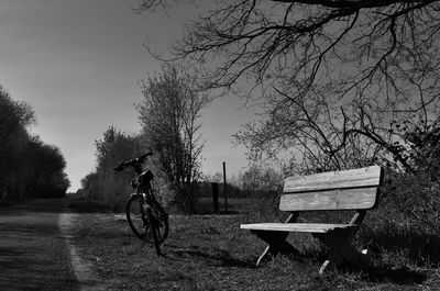 Park bench on field against sky