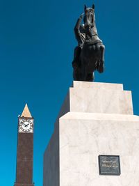 Low angle view of statue against blue sky