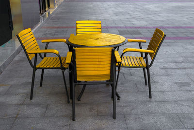 Empty chairs and tables at sidewalk cafe