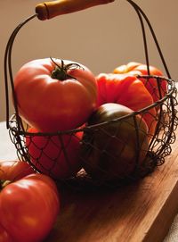 Close-up of fresh tomatoes in basket on cutting board