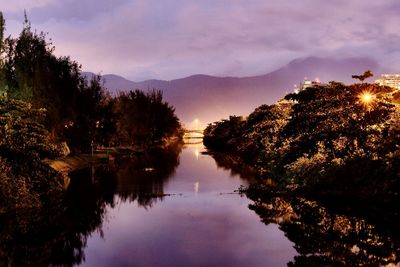 Reflection of trees on water against sky