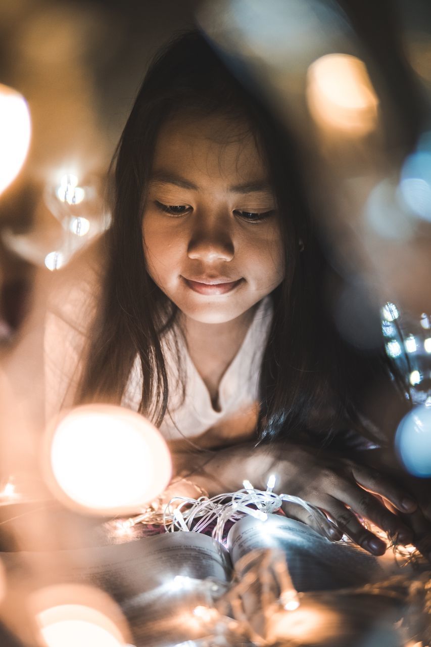 illuminated, headshot, one person, lighting equipment, indoors, real people, portrait, lifestyles, selective focus, glowing, front view, women, leisure activity, girls, child, childhood, celebration, hairstyle, light