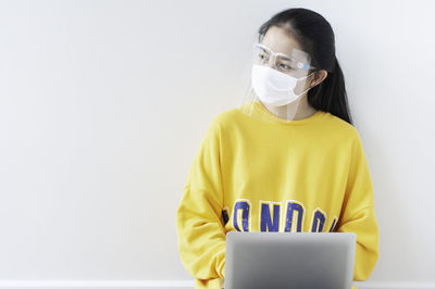 Portrait of woman wearing mask against white background