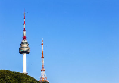 Low angle view of communications tower against blue sky