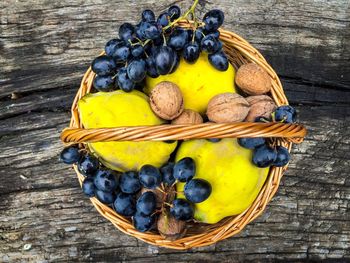 Directly above shot of guava and grapes on wicker basket on table