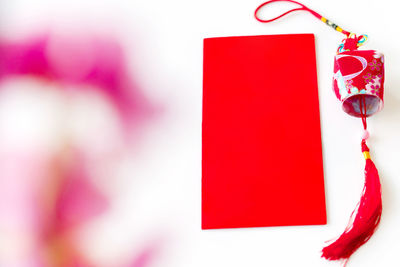 Close-up of red and pink flowers hanging on paper