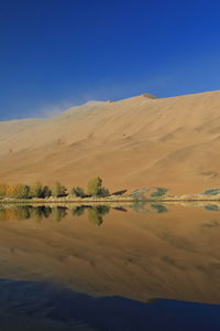 1202 sumu jaran lake's western megadune reflected on mirroring water. badain jaran desert-china.